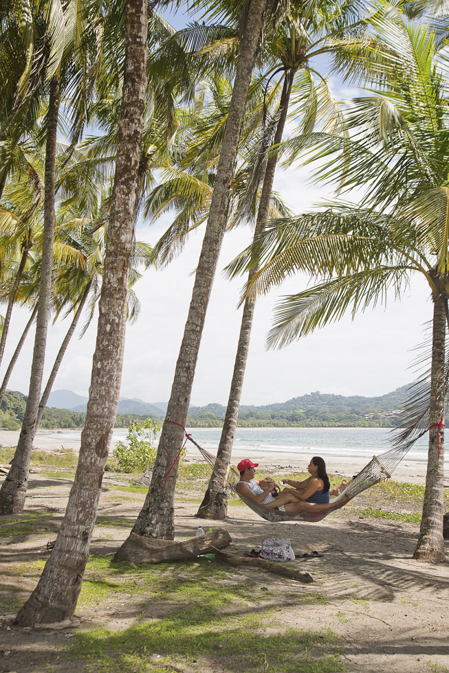 Costa Rica, Provinz Guanacaste, Samara, Playa Carillo, Pärchen chillt in der Hängematte zwischen Palmen am Strand
